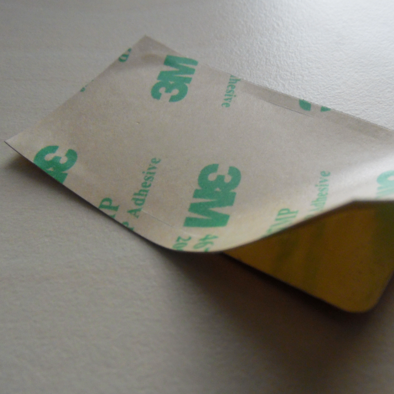 Reverse of metal label showing 3M adhesive